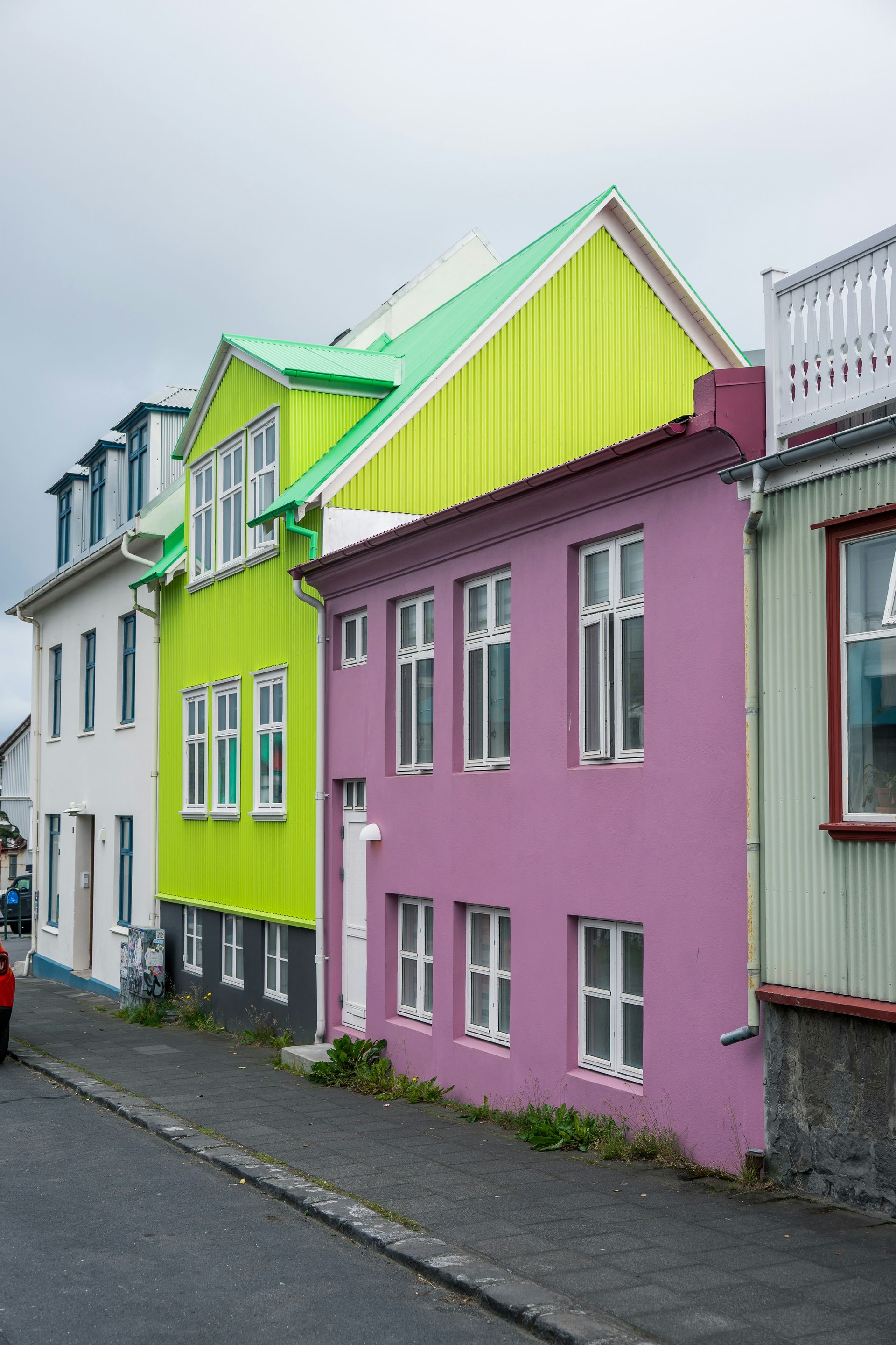 Colorful houses line a street under a cloudy sky